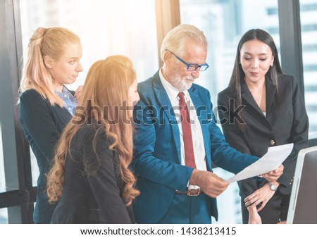 Executive Business Manager is reading report in meeting with female business officer