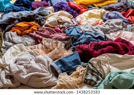 pile of used clothes on a light background. Second hand for recycling Royalty-Free Stock Photo #1438253183