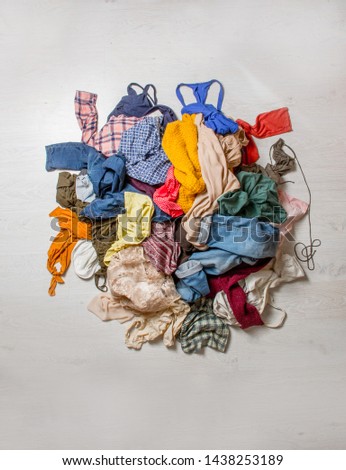 pile of used clothes on a light background. Second hand for recycling Royalty-Free Stock Photo #1438253189