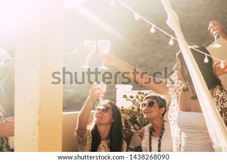 Happy and cheerful group of people females young friends together cheering and toasting celebrating with red wine - happiness and friendship concept during party event for happy women