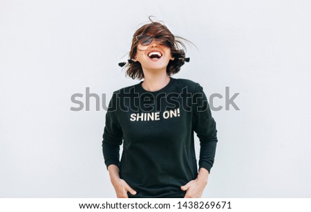 Free feeling happy woman posing in black sweatshirt with positive print Shine On
