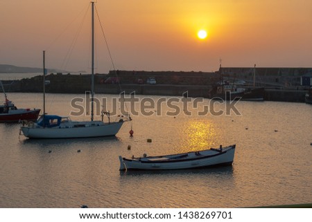 Two small boats moored and anchored in a harbour at sunset in Portrush, Co Antrim, Northern Ireland