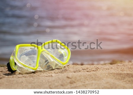 Yellow snorkelling swimming mask on the sandy seaside, diving on the beach