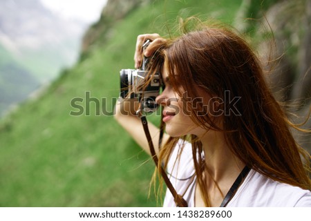 woman takes pictures of the beautiful nature of the mountain