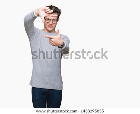 Young handsome man wearing glasses over isolated background smiling making frame with hands and fingers with happy face. Creativity and photography concept.