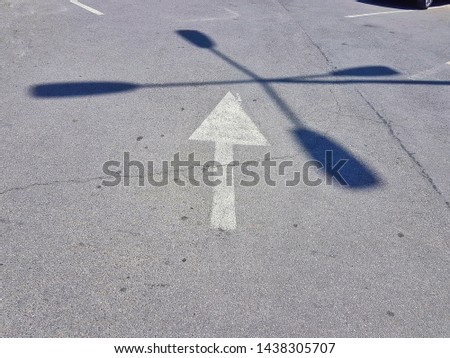 White arrow. Crossing shadows. Abstract image. Beauty of car parking.
 
