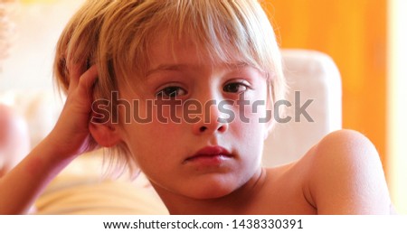 Portrait of handsome blond child boy watching screen at home