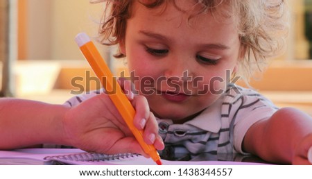 Little boy holding color pen drawing