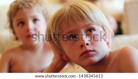 Kids watching movie screen blond children brothers at home
