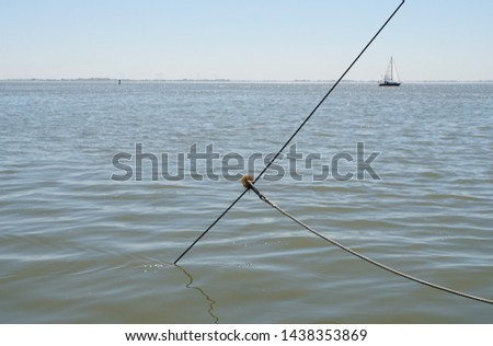 Old Art of Life. Fishing in The North Sea. Fishnet in Sea Water. Straightened Trawler Net Is Going Down To The Bottom of The North Sea. Blue Background.