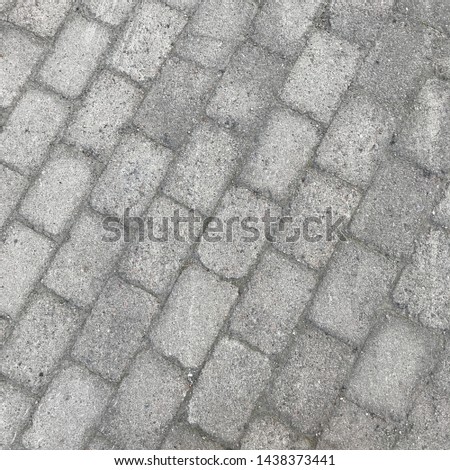 Grey brick wall and road texture background. Tiled.