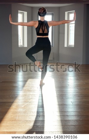 Morning yoga girl doing stretching exercises in the room for Pilates. Beautiful light, air photos, a healthy lifestyle, body hormones and soul, illumination, copy space.