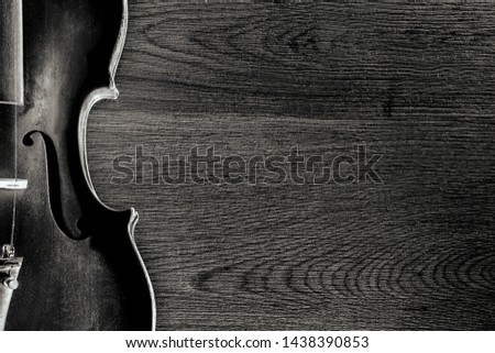 black and white photo, violin and bow close-up on a wooden board, top view