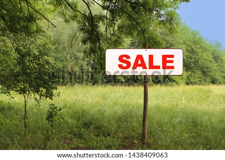 white sign, road sign in the forest on a wooden post with the inscription sale, concept
