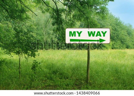 white sign, road sign directions in a green summer forest on a wooden post with the inscription my way and an arrow, concept