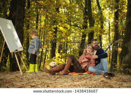 Art and self expression. Talent development. Painting skills. Mom and dad relax park picnic while kid painting. Rest and hobby concept. Parents watching their little son painting picture in nature.