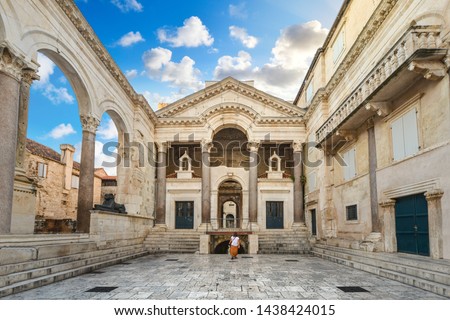 A woman walks through the Peristil or Peristyle Square of the ancient Diocletian's Palace in the old town area of Split, Croatia early in the morning. Royalty-Free Stock Photo #1438424015