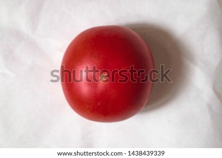 Fresh single tomato isolated on white paper background