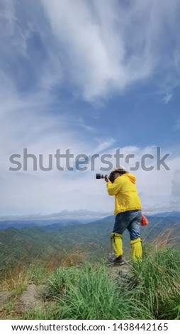 Tourists stand to take pictures at the viewpoint with mountains and beautiful skies, the rainy season of Southeast Asia.