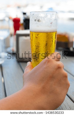 Close up picture of man holding cold draught beer at a restaurant