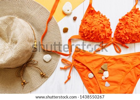 Summer flat lay with swimsuit, hat and sea stones. Modern fashion background. Top view collage with summer accessories