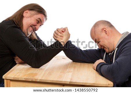 Adult men are engaged in armwrestling. Close-up, isolated on white background.