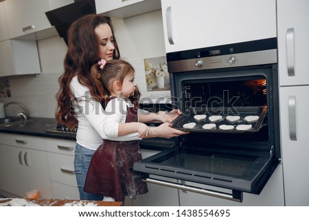 Family in a kitchen. Beautiful mother with little daughter