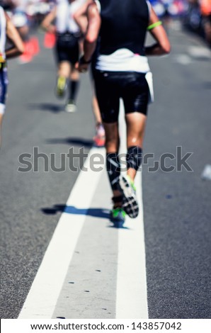 Photo of a marathon competition during an ironman. Focus on the foreground , no faces recognizable. Shallow depht of field.