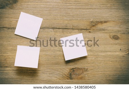Stickers on a wooden background. Piece of paper on wooden table.