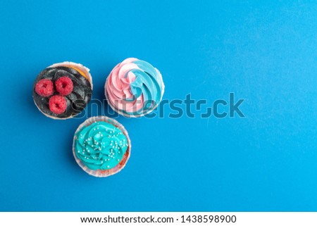 Birthday cupcakes on blue background close up
