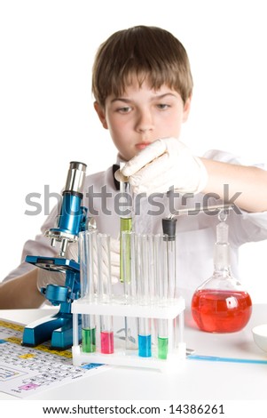 The boy with a microscope and various colorful flasks on a white background. Selective focus.