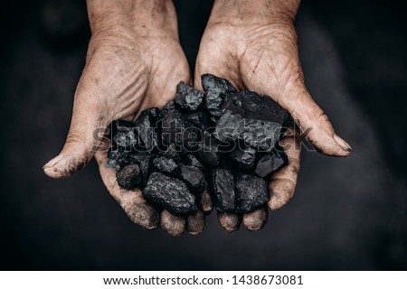 Miner holds coal palm. Concept mining. Top view Royalty-Free Stock Photo #1438673081