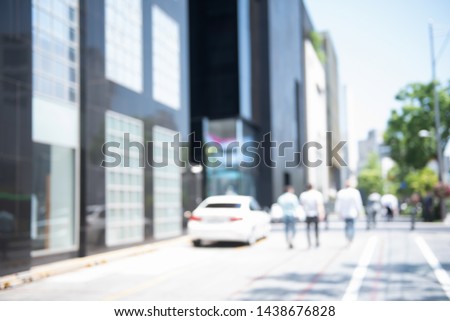 Blurred background of asian people, businessman walking on sidewalk and traffic on the road with business building, business area in the city, Seoul Korea, perspective.