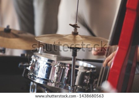 Live music background, drum set and red electric double bass, close-up photo with selective soft focus