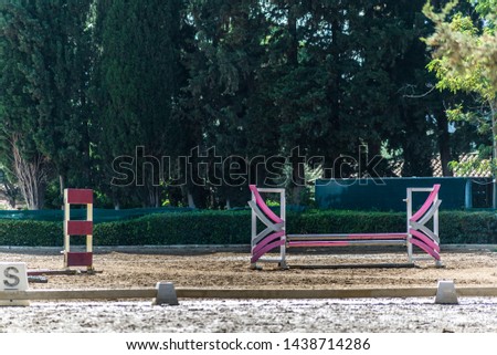 Equestrian club with obstacles and terrain, external space, landscape with trees in daylight. 