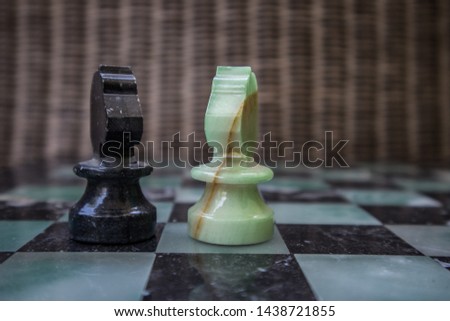 Chess pieces on a marble chessboard, closeup, arranged in random viewing