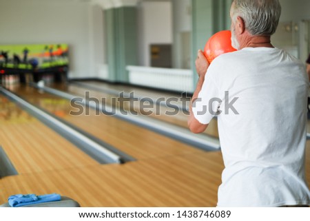 Rear view caucasian old man playing bowling