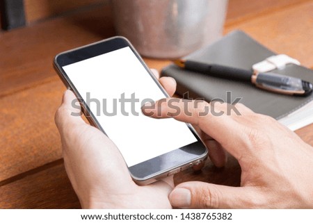 man using mobile phone with blank screen on wooden table, outdoor scene