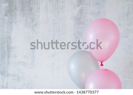 pink and gray balloons for birthday party on a gray concret background with a copy space