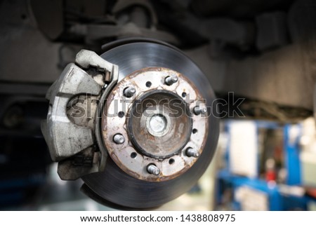 Close up of Brake Disc of the vehicle for repair.Automobile mechanic in process of new tire replacement.Car brake repairing in garage.Car Service and technician concept.