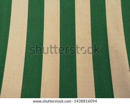 Closeup on the green and white striped fabric of an old deck chair