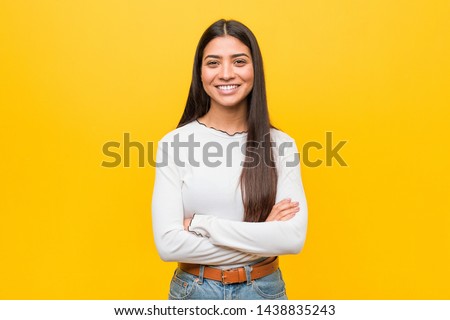 Young pretty arab woman against a yellow background who feels confident, crossing arms with determination.