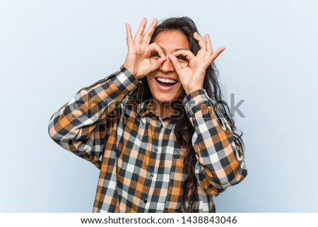 Young cool indian woman showing okay sign over eyes