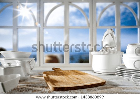 Desk of free space for your decoration in kitchen. White wooden big window and summer landscape of sea with sun and blue sky. Summer time and sunny day time. 