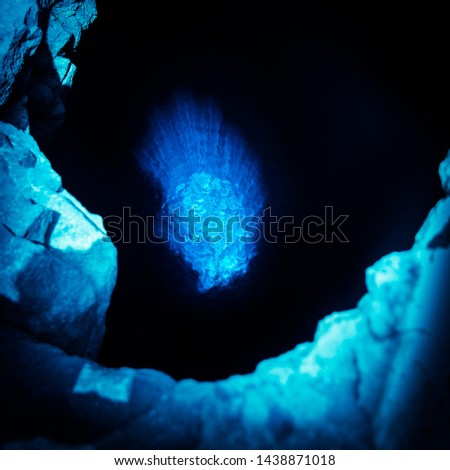 Blue Eye, Sal, Cabo Verde Islands, Africa. Natural tropical island landmark of sea water basin and sun rays reflection deep in cavernous hole. Midnight blue foreground moonlight effect, Birds eye view
