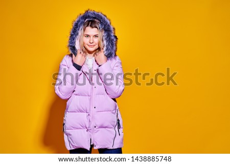 Young fashion woman in short violet down jacket.