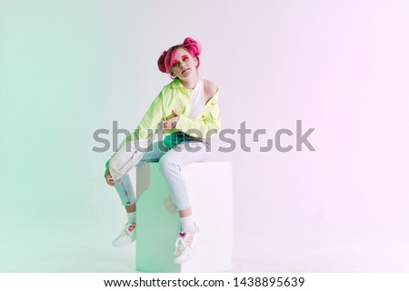 woman with pink hair sits on a cube studio fashion