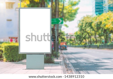 big blank billboard white LED screen vertical outstanding in the city side the road traffic for display advertisement text template promotion new brand at outdoor with green tree vintage color tone.