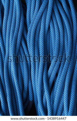 Come to us, we have many of this. Isolated photo of climbing knots. Top view of blue colored cables.