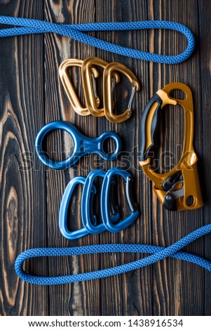 Rotated picture. Isolated photo of climbing equipment. Parts of carabiners lying on the wooden table.